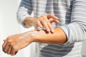 person applying lotion to their arm